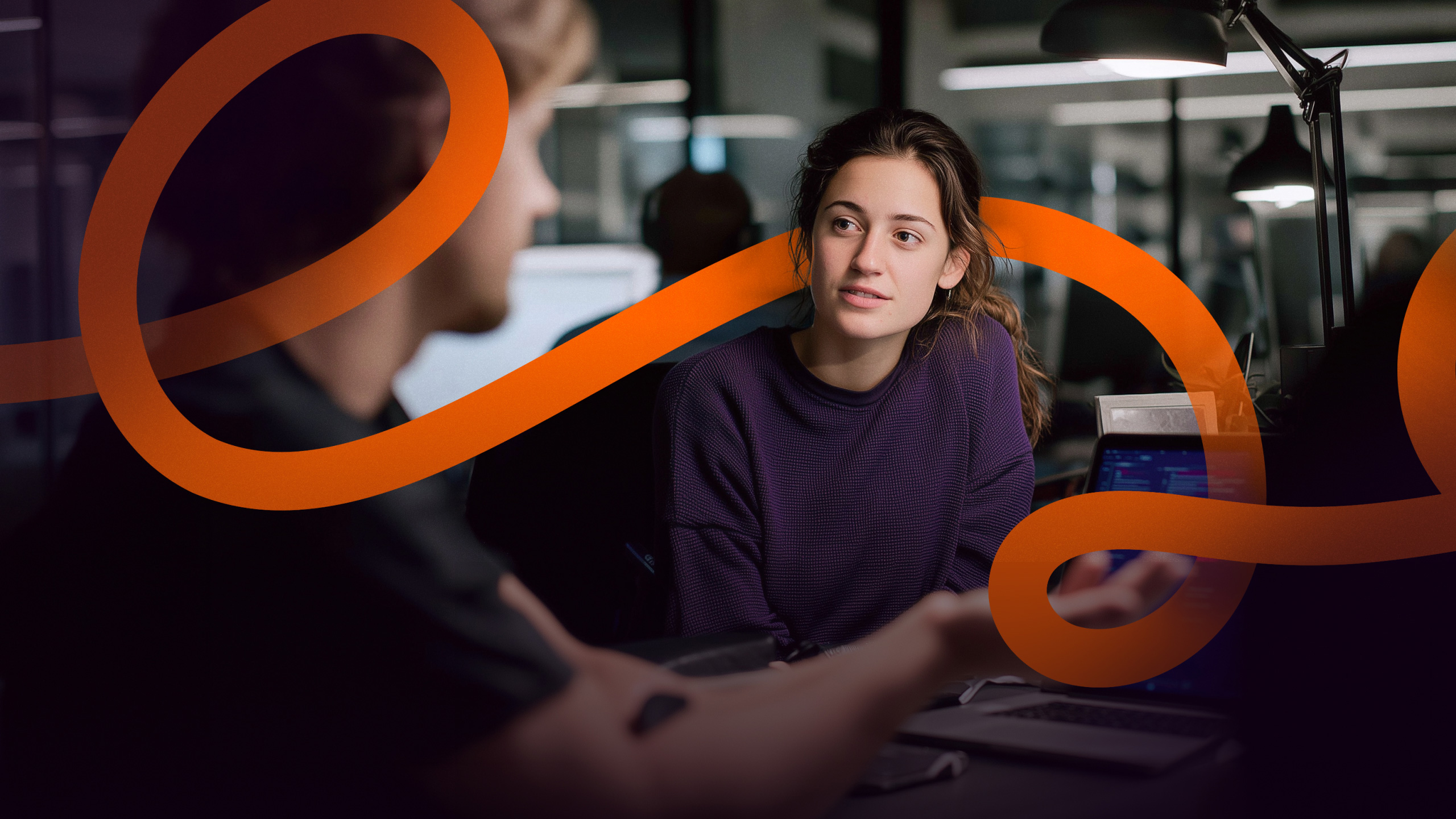 Night office scene with the orange line running across the frame between two colleagues in conversation