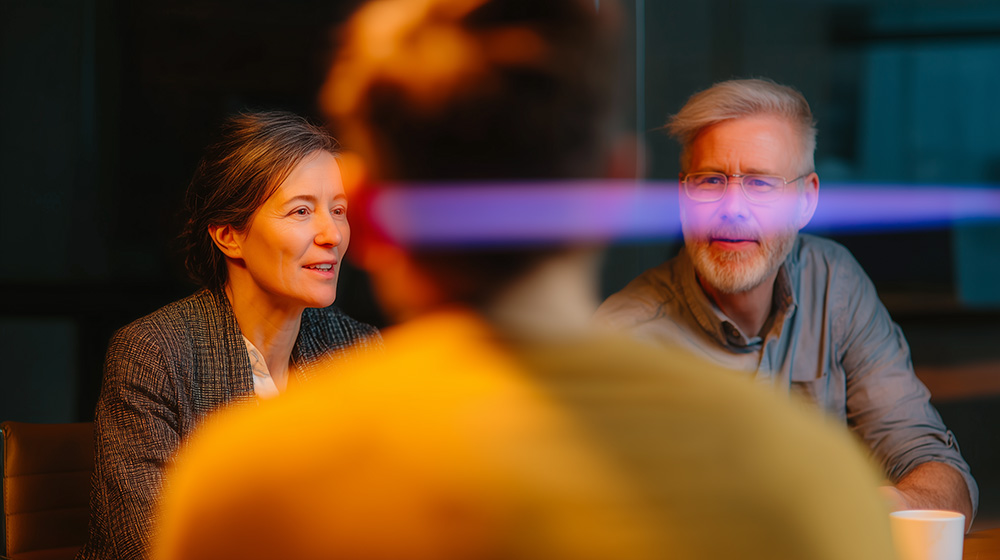 Two colleagues in a meeting with cinematic orange and purple light in the background